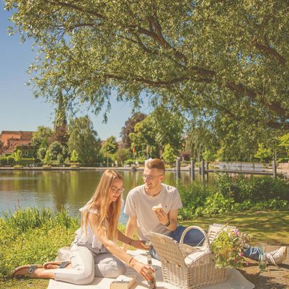 Pärchen beim Picknick in der Eutiner Stadtbucht. Im Hintergrund ist die St. Michaeliskirche zu sehen.