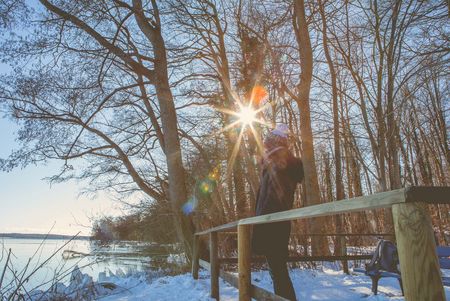 Winterlandschaft mit Bäumen und Schnee davor ein Wanderer