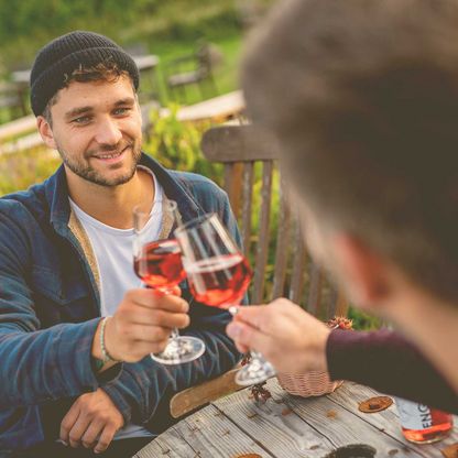 Zwei Männer stoßen mit einem Wein an.