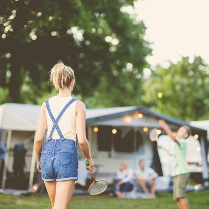 Ein junges Mädchen spielt Badminton auf einem Campingplatz