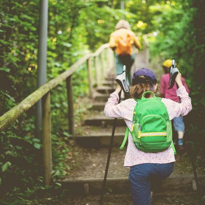 Eine Frau mit Kindern steigen Stufen hinauf zum Jagdschlösschen