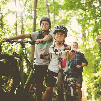 Vierköpfige Familie zusammen auf Fahrradtour im Wald