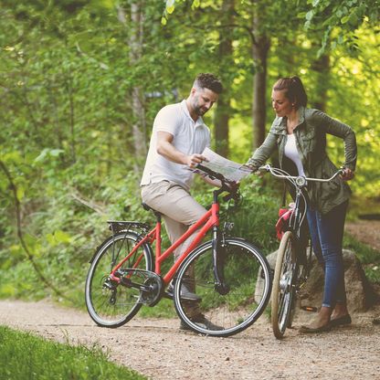 Zwei Radfahrer lesen eine Karte. 