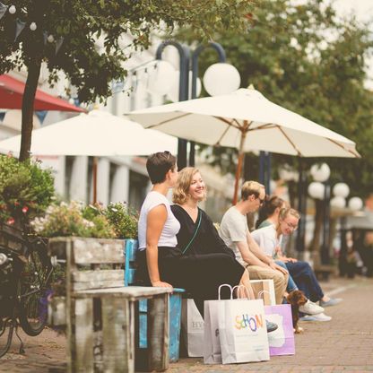 Menschen sitzen auf Bänken am Eutiner Marktplatz