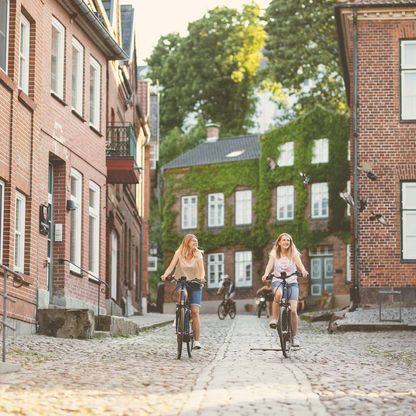 Zwei Mädchen fahren den Schloßberg in Plön runter.