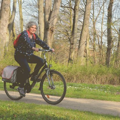 Eine Frau fährt mit dem Fahrrad durch den Eutiner Schlossgarten