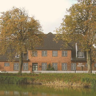 Ein Dorfmuseum hinter einem Fluss.