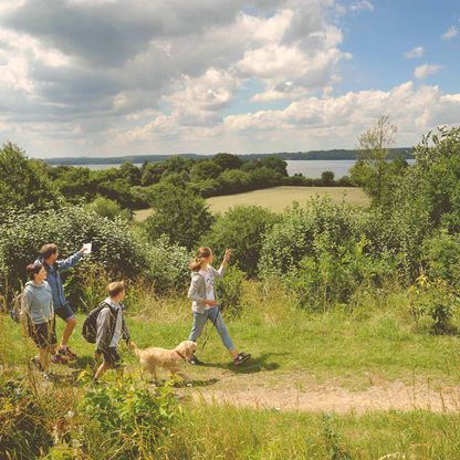 Eine Familie wandert mit ihrem Hund durch die Natur