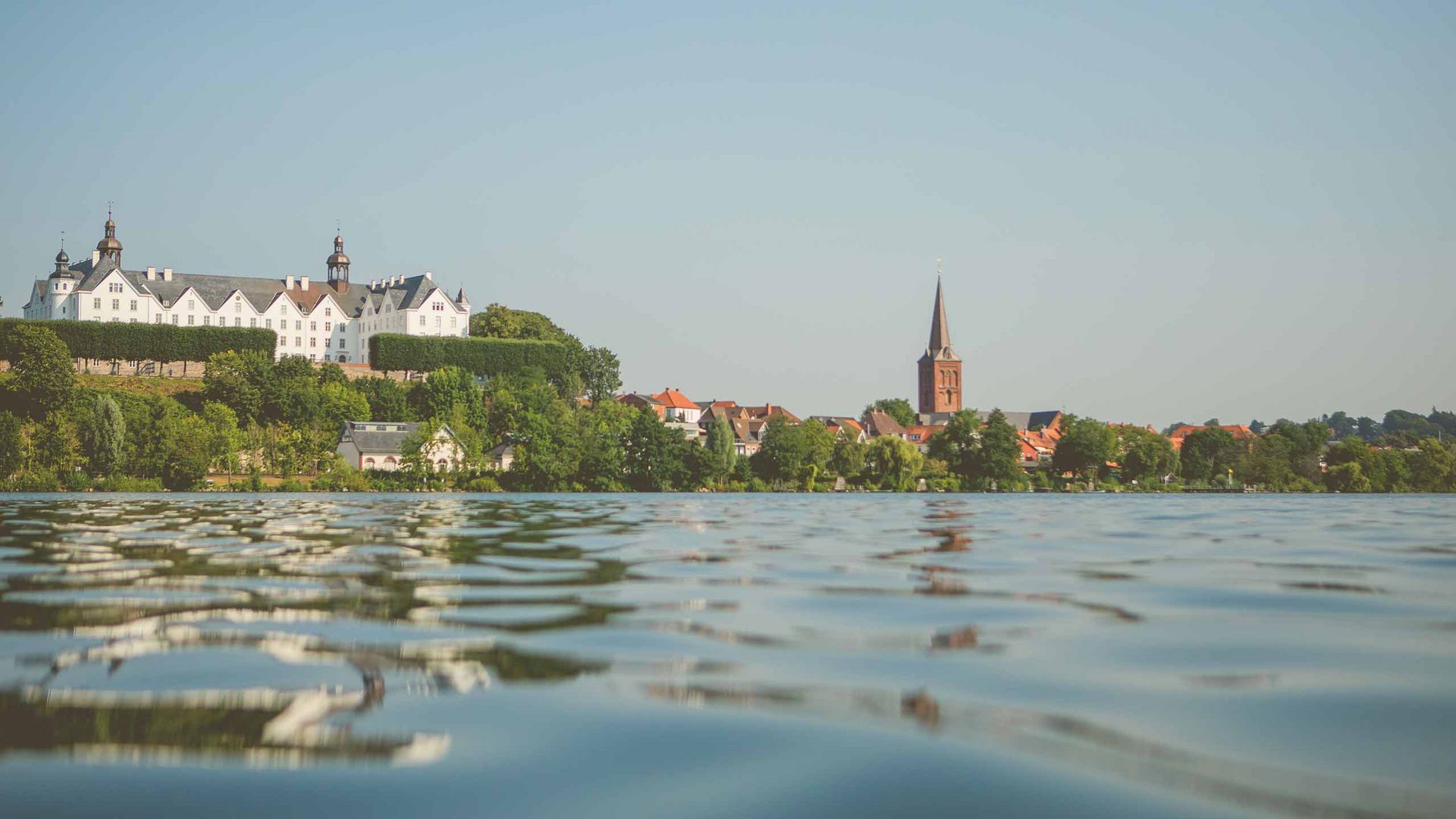 Schloss Plön: Blick vom Wasser aus auf Plöner Schloss und Stadtbucht